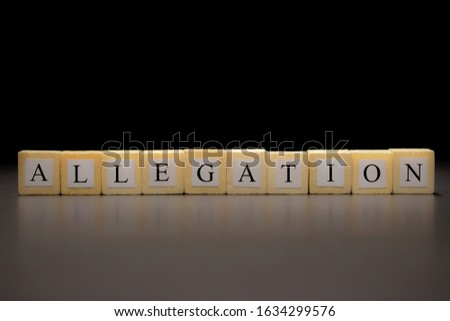 The word ALLEGATION written on wooden cubes isolated on a black background... Royalty-Free Stock Photo #1634299576