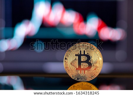 Gold Bitcoin crypto currency on background of chart diagram.