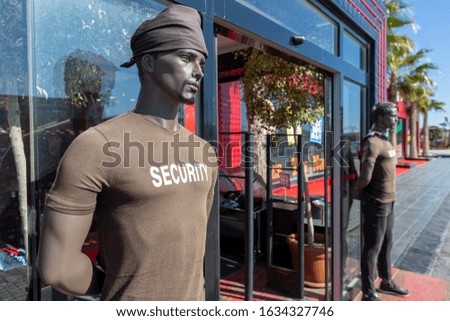 Male security puppet stands on a store