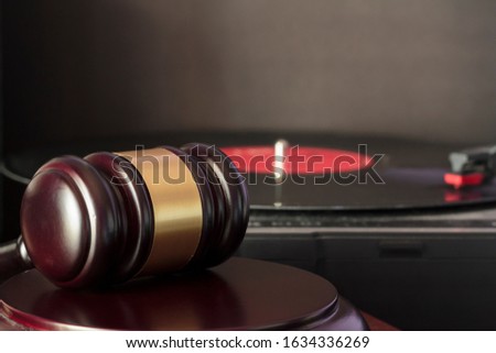 Judge's gavel and vinyl record player. Concept of entertainment lawsuit, music piracy and copyright protection Royalty-Free Stock Photo #1634336269