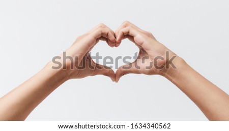 Man hands making a heart shape on a white isolated background Royalty-Free Stock Photo #1634340562