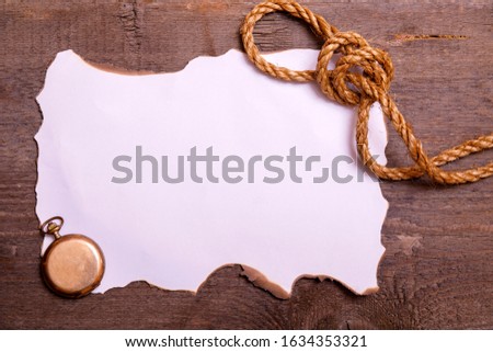 Abstract grunge background. Old broken horizontal sheet of paper on brown wooden board with empty space for text.