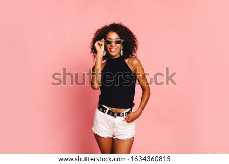 Portrait of smiling young black woman with copy space
Fashion pretty young smiling african woman wearing stylish swag outfit at pink background. Horizontal. copy space, shopping.