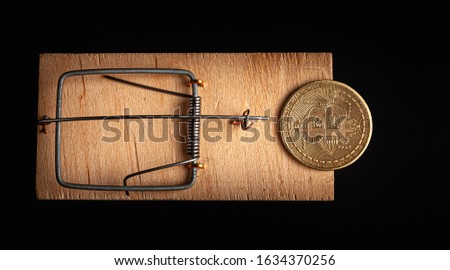 Bitcoin coin in a mousetrap isolate on a black background. Stock photo bitcoin news.
