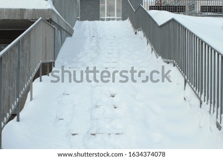 Stairs covered with snow, after a heavy snowfall in winter. The concept of bad weather. Stock photo for web and print with empty space for text. 