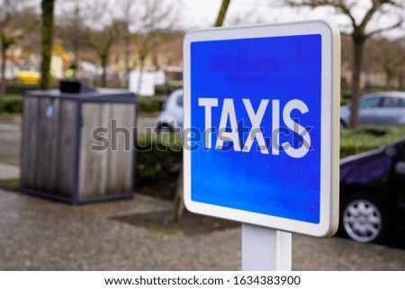 taxi blue sign service signage hanging on pole street