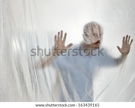 Silhouette of a man behind a transparent plastic