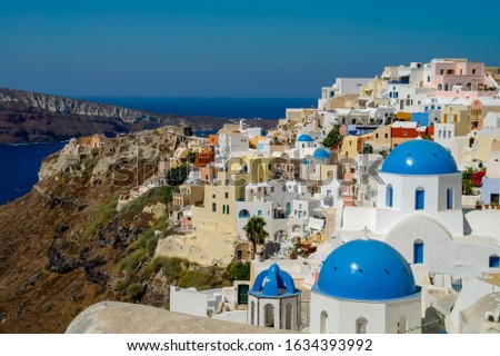 View of the Santorini caldera, taken from Oia, with houses, monuments, churches, cruise ships and ferries in the Aegean Sea. Santorini, officially Thira, is an island in the Cyclades, Greece