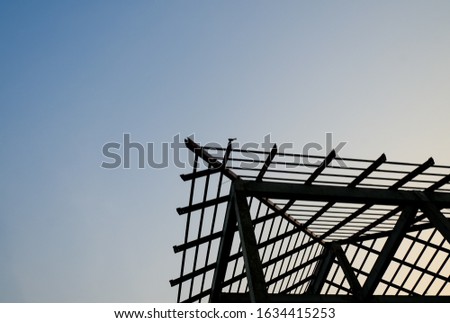 silhouette corner steel structure roof house building. unfinish home project construction site. copy space with blue sky 