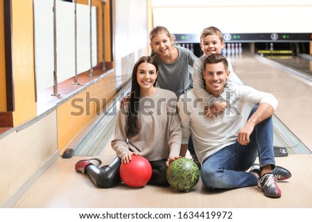 Happy family spending time together in bowling club