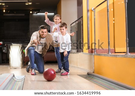 Happy family spending time together in bowling club