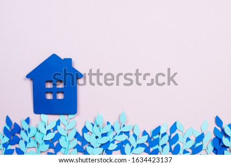 paper blue house with blue paper flowers on a pink background