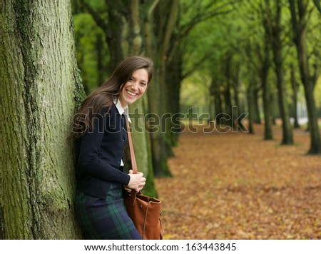 Portrait of a young woman smiling and relaxing outdoors on an autumn day