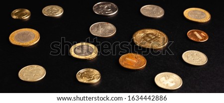 Set of different coins on a black background. Stock photo assortment of coins of different countries.