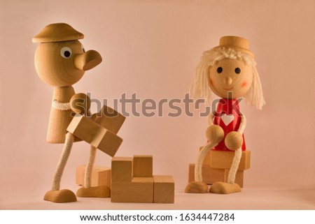 Retro handcrafted old wooden toys of cubes, girl and boy for children. Nostalgia and simplicity concept.