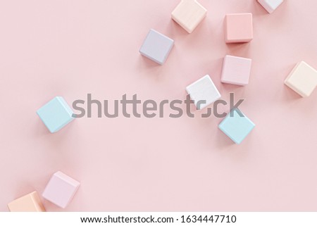 Colorful wooden toy blocks. Stylish baby toys on pastel pink background. Eco friendly, plastic free toys accessories for kids. Flat lay, top view