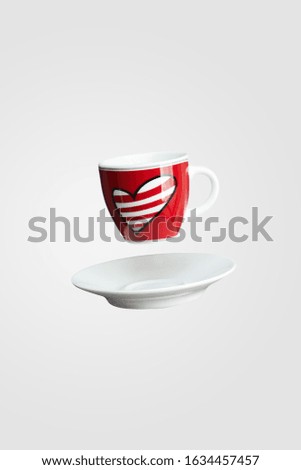 Heart on red cup of coffee balancing in the air or falling isolated on white background, levitation creative design, St Valentine's, mothers or womens day concept, closeup