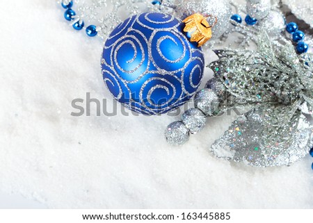 Silver christmas baubles on white snow background