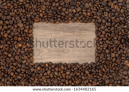 Mixture of different kinds of coffee beans on wood background with place for text. Studio shot for designers.