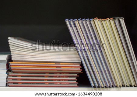 Stack of various books or comics on a shelf of a bookstore.