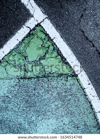 Signage for traffic painted on the ground, cracked lines and colors