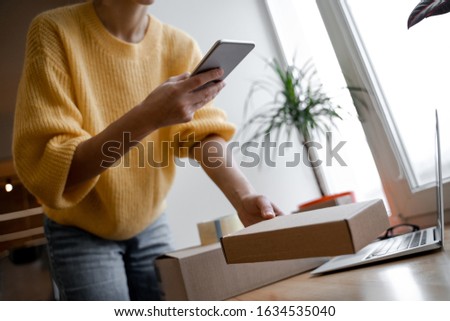 Young small business owner fills the base and photographs new products for the client, selling online on a website. Online Sales, E-Commerce, E-Business, with postal parcel, selling online