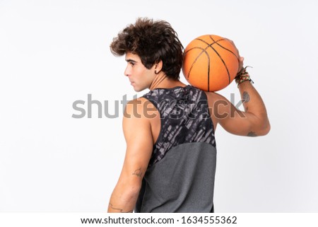 Young caucasian man over isolated white background playing basketball in back position