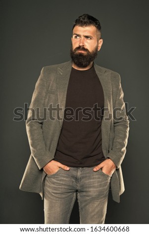 For ultimate comfort. Hipster in casual and comfy outfit keeping arms in pockets on grey background. Bearded man wear casual style. Casual and comfortable. Fashion wardrobe is casual enough.