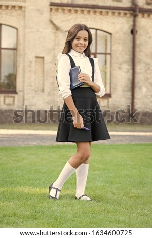 Always full of inspiration. Happy little girl back to school. Adorable little child with long brunette hair in formal wear. Little schoolchild smile at school. Cute little kid go to literature lesson.