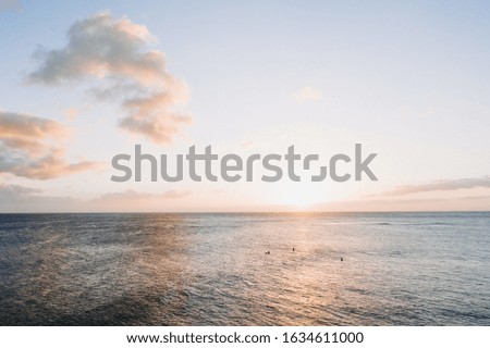 A beautiful shot of a sunrise in the open sea with a clear blue sky