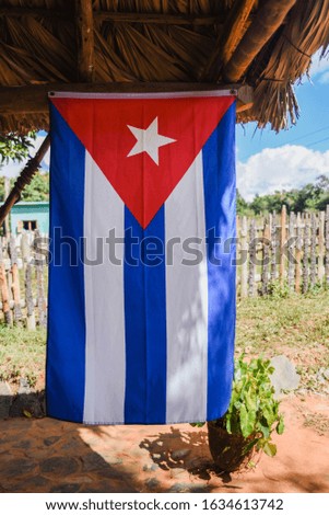 A Cuban flag hanging outdoors.