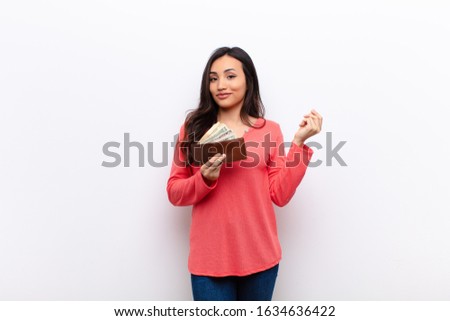 young latin pretty woman  against flat wall money concept