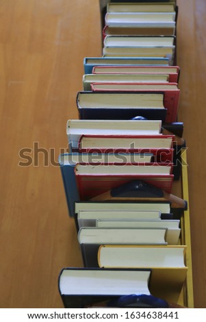 The picture on top of many books are arranged in rows on the library table selective focus and shallow depth of field