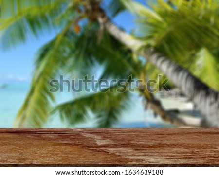 Wood table top on blurred blue sea and white sand beach background - can be used for display or montage your products