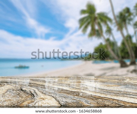 Marble table top on blurred blue sea of the background