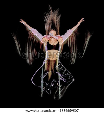 one caucasian young woman modern dancer dancing isolated on black background with light painting motion blur speed effect