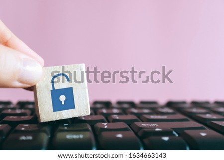 Closed up unlock icon as non security show on wood cube on computer keyboard. Protect safety on network activity business technology concept.