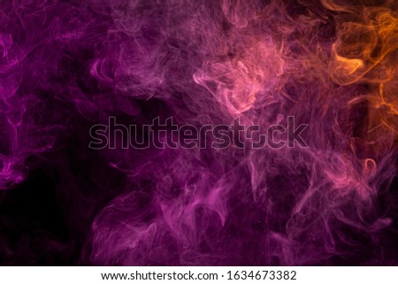 Colorful pink and red smoke  on a black isolated background. Background from the smoke of vape.  Abstract artwork. 