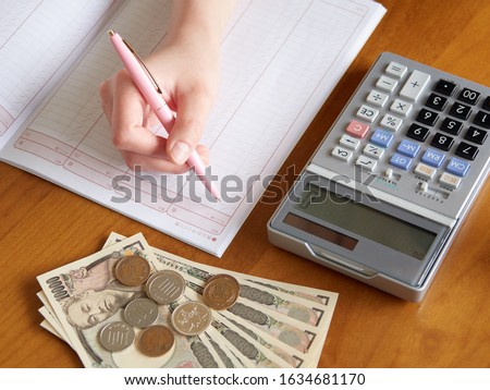 A woman who manages money with a household account book Royalty-Free Stock Photo #1634681170