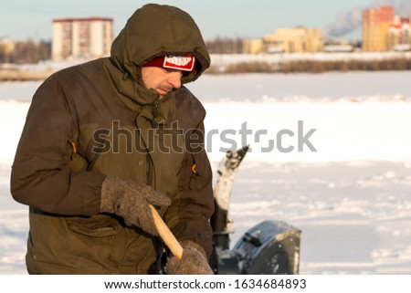 Portrait of a worker cleaning snow with a shovel on a background