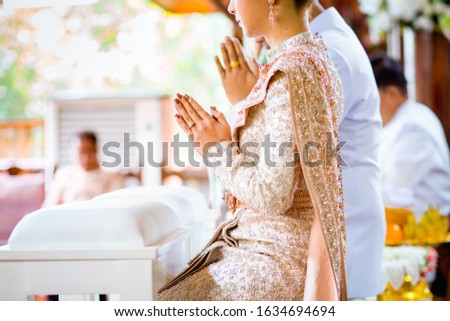 Do not focus, do not focus on the person in the picture. Blurred young women and young men. Young women raising hands to pay respect (Phanom hands) at a Thai wedding ceremony