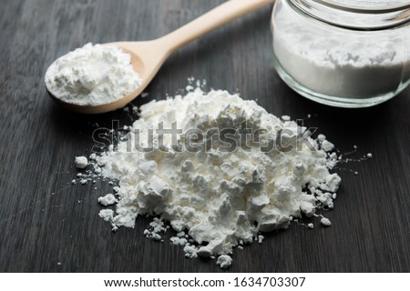 Close-up of tapioca starch or flour powder in wooden spoon with wooden background Royalty-Free Stock Photo #1634703307