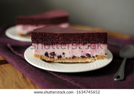 No baked cheesecake with blueberry on white plate. Dark background.