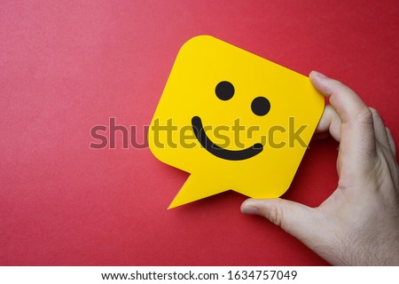 Customer service experience and business satisfaction survey. Man holding yellow speech bubble with smiley face on red background. Royalty-Free Stock Photo #1634757049