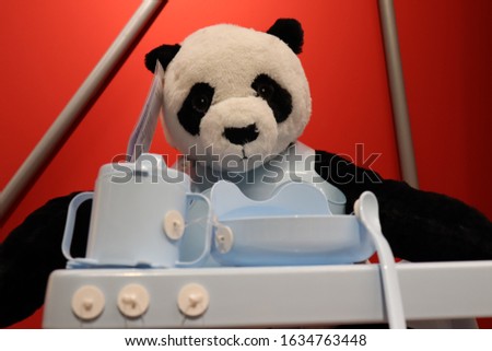 Panda sitting on a baby walker.