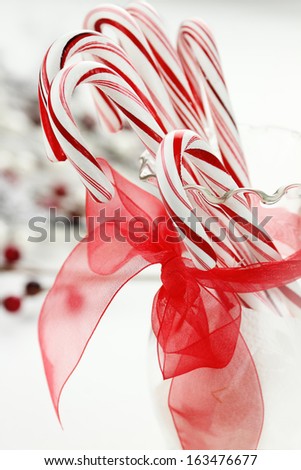 Candy canes in a glass dish with pretty red ribbon.