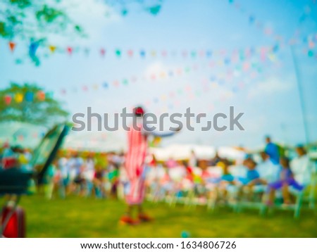 Blurred images of Funny magicians,joker, and Colorful flags, colorful party decorations, small triangular flags to celebrate the party with the blue sky and clouds as the holiday concept background.