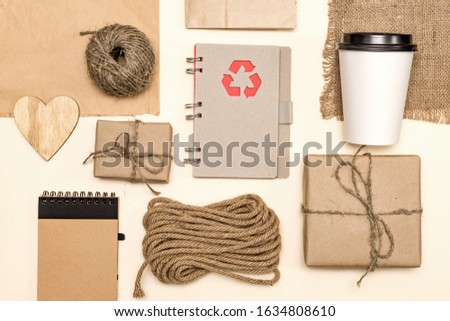 products made from recycled kraft paperand wood: packages,  notebook, disposable coffee cup, wooden heart, cord. concept of environmental protection, recycling business. top view 