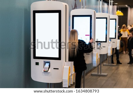 Self-service desk with touch screen and payment terminal in fast food restaurant Royalty-Free Stock Photo #1634808793