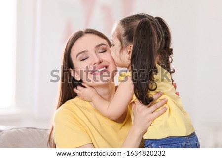 Young mother with little daughter at home